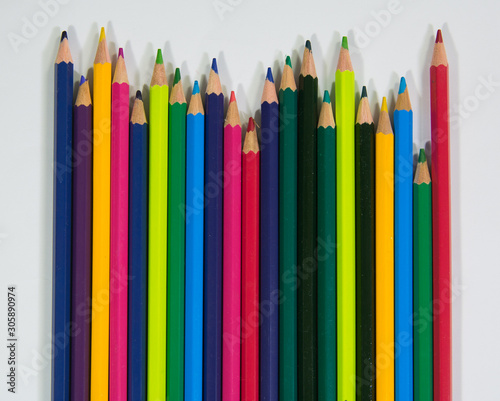 set of wooden color pencils with different lengths with upside frontal view on white background