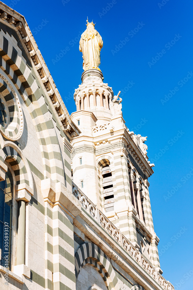 Fototapeta premium Beautiful view of Notre Dame de la Garde in Marseille against a bright blue sky on a sunny day.
