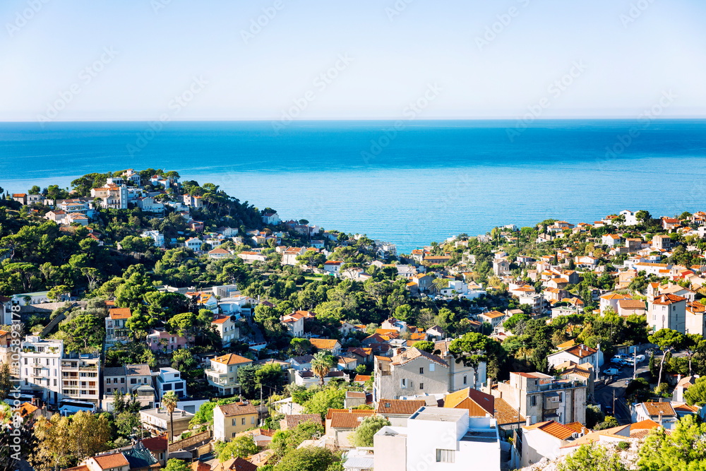 Beautiful top view of a European city on the coast of the sea. White houses with orange roofs, bright blue sky on a sunny day. Great landscape.
