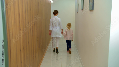Doctor walks with girl along the corridor 