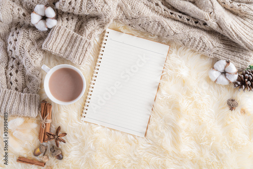 Autumn or winter composition. Gift box Coffee cup, notebook, anise stars, beige sweater on cream color knitted blanket background. Flat lay top view copy space.