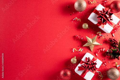 Christmas background concept. Top view of Christmas gift box red and golden ball with snowflakes on light red pastel background.