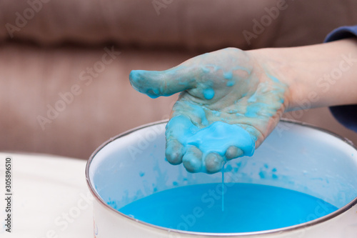 Closeup of kids hand holding substance, cornstarch and water mixture, doing a science experiment photo