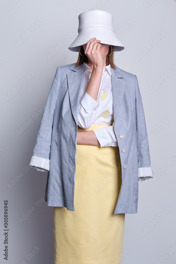 Lady touching white hat and hiding her face Lady touching white hat and hiding her face