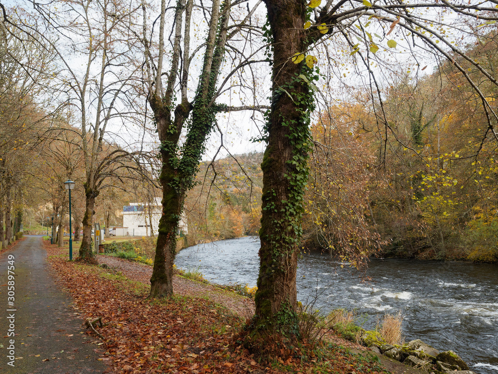 Fototapeta premium Paysage pittoresque aux couleurs d'automne du parc floral des thermes Châteauneuf-les-Bains au bord de la Sioule dans le Puy-de-Dôme