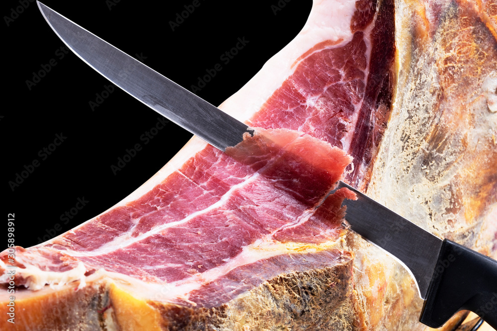 Φωτογραφία Professional cutter carving slices from a whole bone serrano jamon