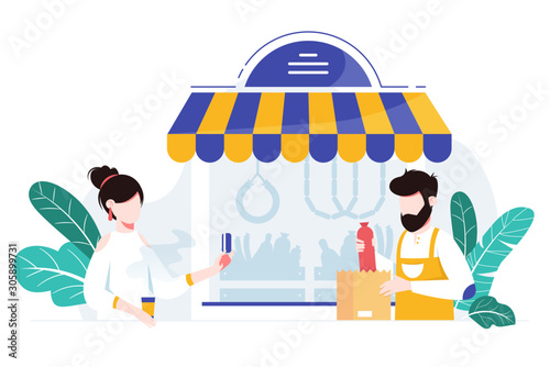 Customer making a purchase at local meat shop. Helpful shopkeeper wearing apron packs fresh sausage and meat in a store.