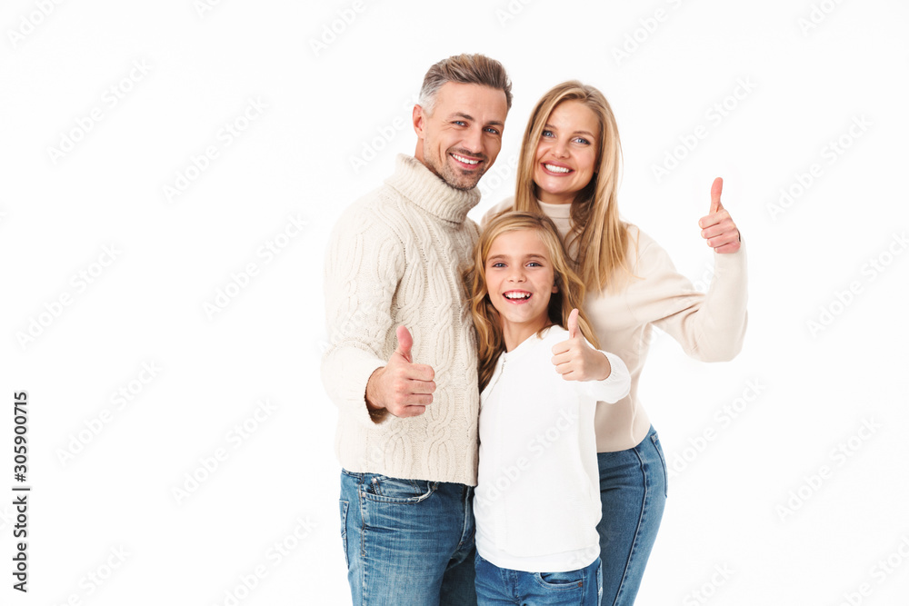 Image of family in winter clothes gesturing thumbs up and smiling Image of family in winter clothes gesturing thumbs up and smiling