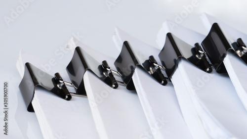 Close up of white office working document stacking with black paper clip folder on white background