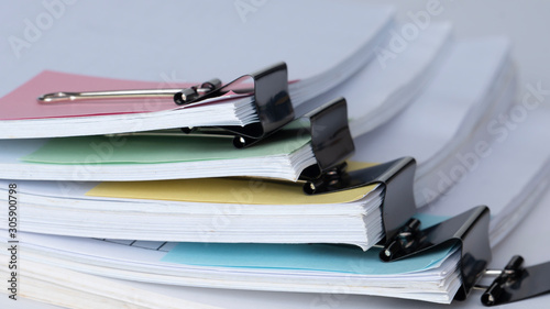 Old office working document with pastel note paper and black paper clip folder on white background