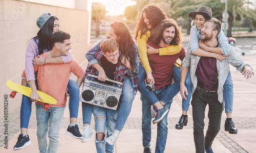 Happy friends having fun walking piggyback in the city center - Group young people laughing and sharing time together outdoor - Youth culture . friendship people lifestyle concept photo