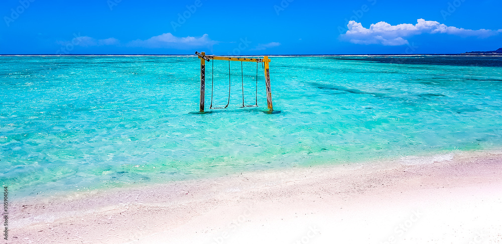 Gili Islands, Indonesia, Asia. Beautiful beach crystal clear water and white sand in an exotic tropical destination. Famous wooden water swing. Popular instagram location. 