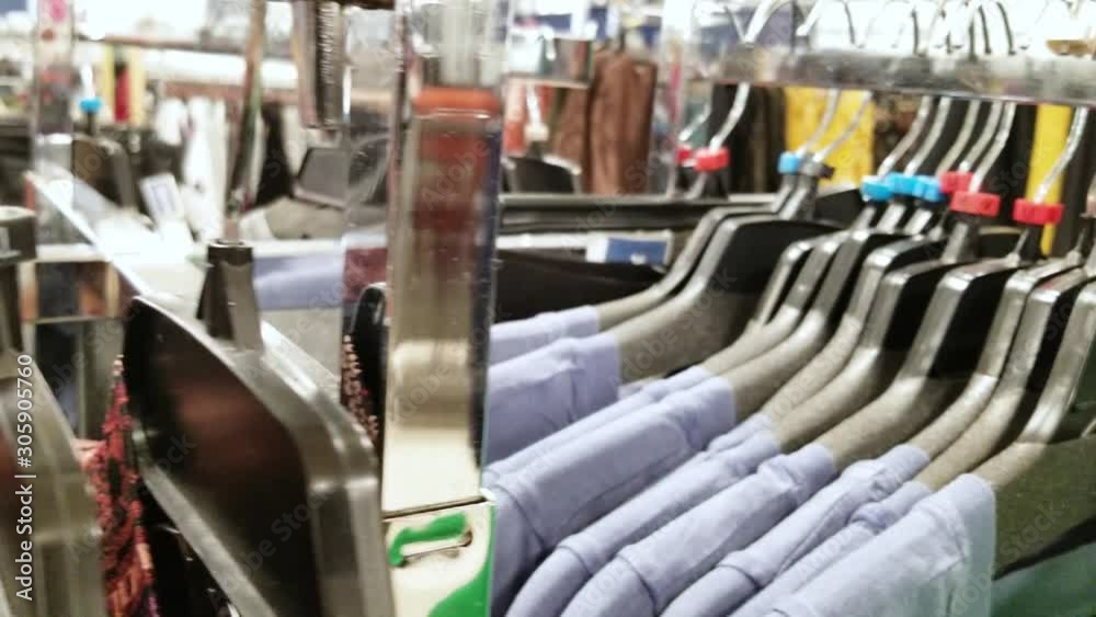 Close-up shows sizes on clothes hangers in a store. Extra Small, Small, Medium
