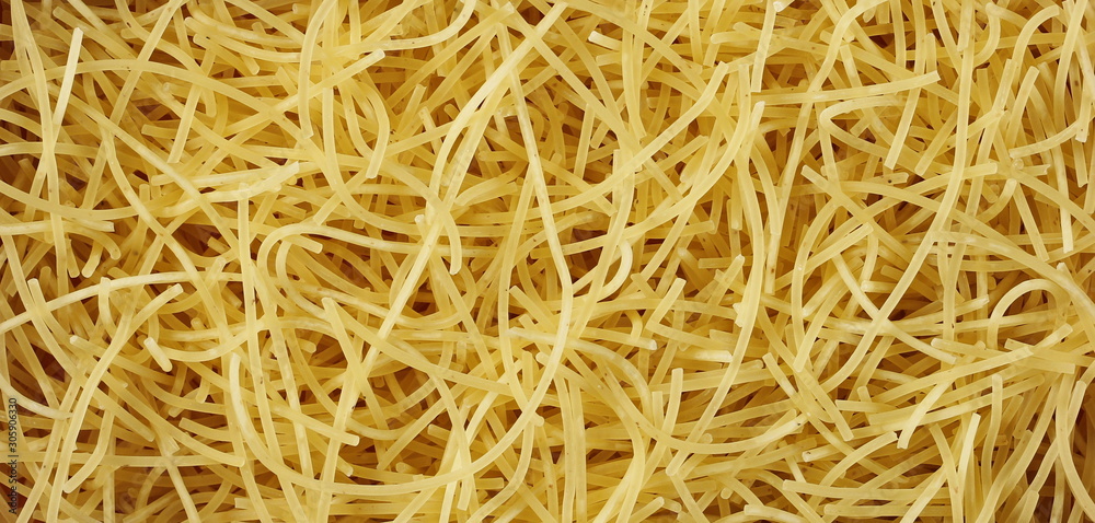 Dry, raw egg pasta noodles background and texture
