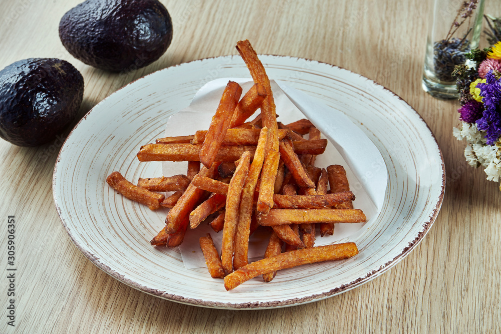 Deep-fried sweet potato straws on grey plate. Close up view. Vegetarianf food. Street food Deep-fried sweet potato straws on grey plate. Close up view. Vegetarianf food. Street food