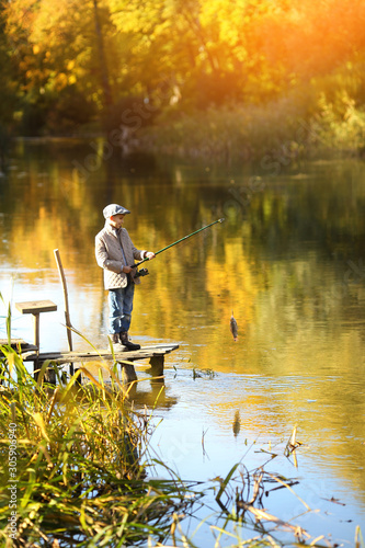 Boy Catching a Fish from wooden dock.