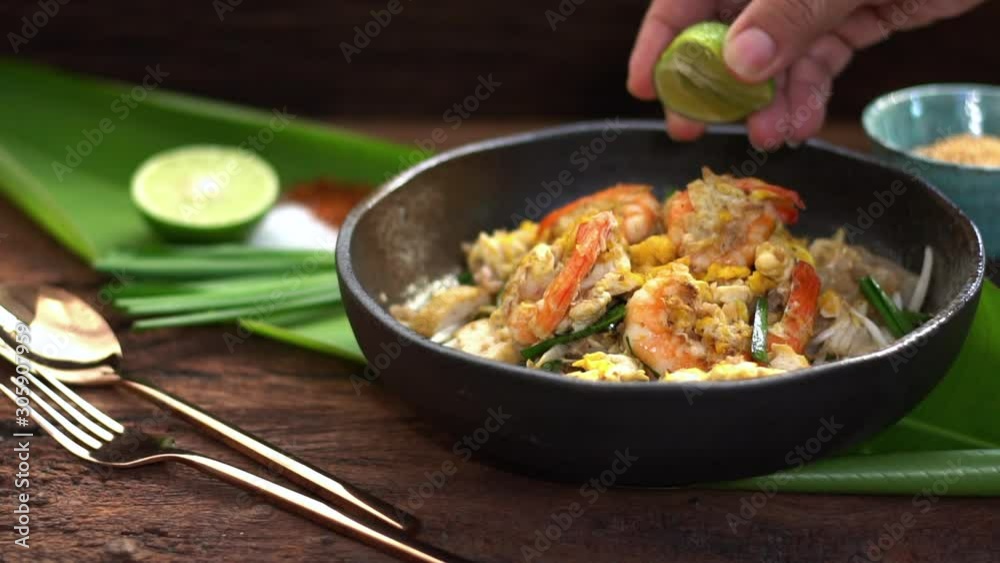 Thai traditional food: Pad Thai, stired noodles with shrimps, egg served with lime,vegetable. How to cooking Pad Thai on street food, Thailand, Clean food good taste concept. Thai traditional food: Pad Thai, stired noodles with shrimps, egg served with lime,vegetable. How to cooking Pad Thai on street food, Thailand, Clean food good taste concept.