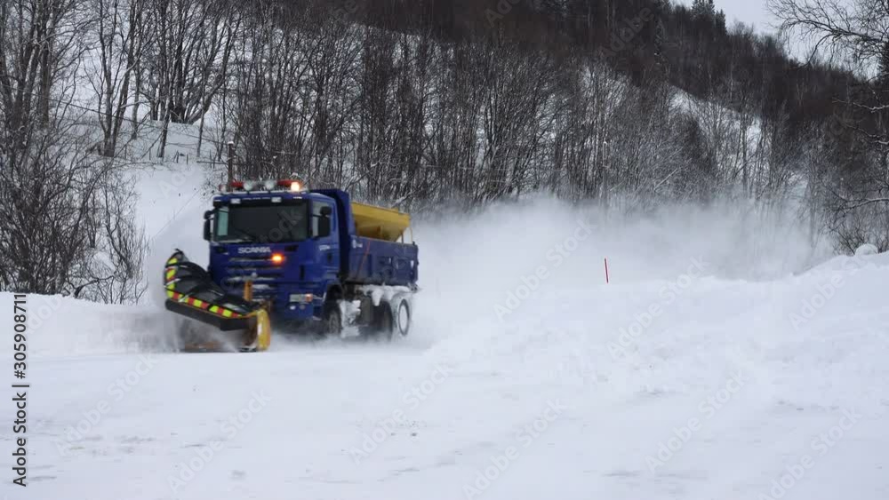 TROMSO, TROMS, NORWAY, MARCH 06 2019: snow plow truck cleaning a snowed winter road TROMSO, TROMS, NORWAY, MARCH 06 2019: snow plow truck cleaning a snowed winter road