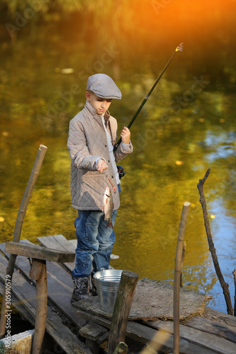 Boy Catching a Fish from wooden dock. © azhurfoto