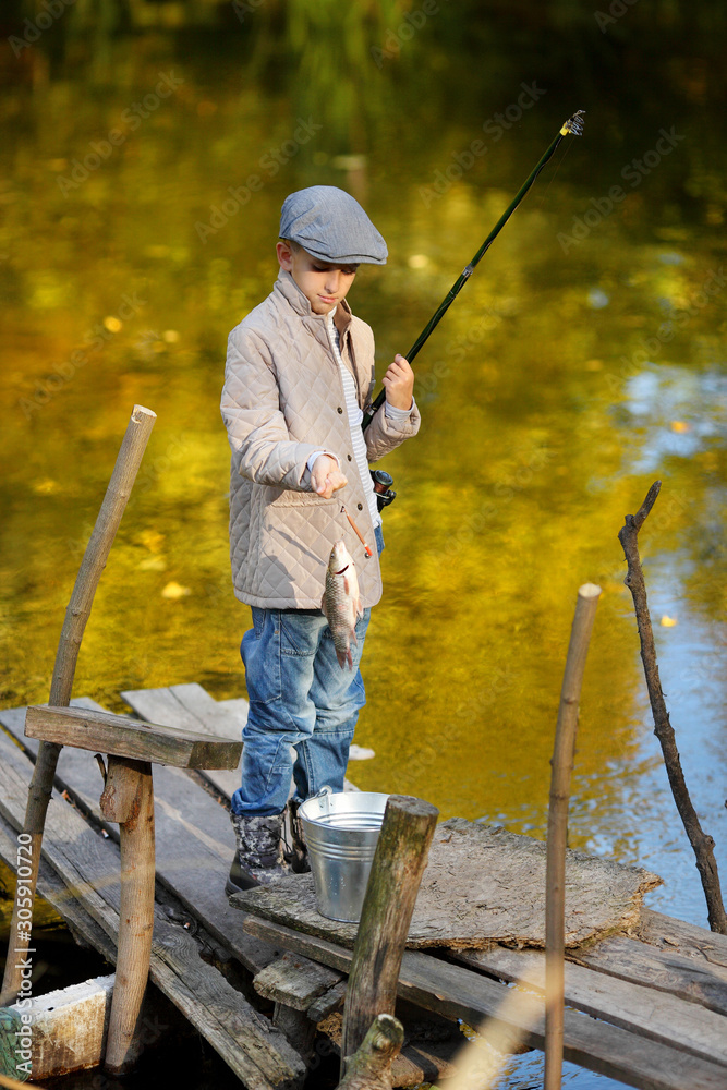 Boy is fishing at sunset on the lake Boy is fishing at sunset on the lake