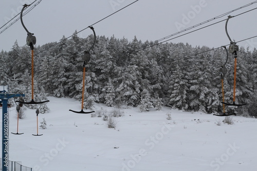 Ski-lift for skiers and snowboarders with sticks in winter on a snowy hill photo