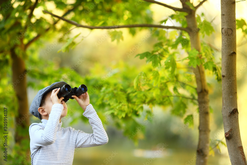 portrait of a little boy looking through the binoculars portrait of a little boy looking through the binoculars