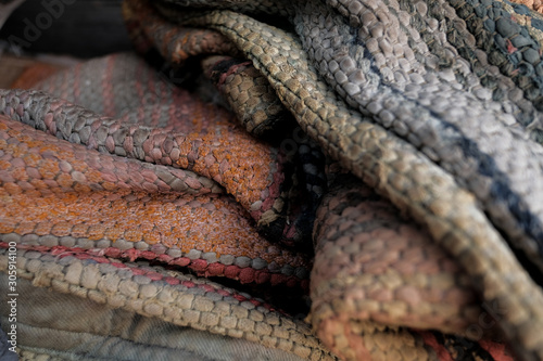 Needlework. Textile background with fabric texture with horizontal lines. A rug for home made from colorful patches of old things. Sewn in rows