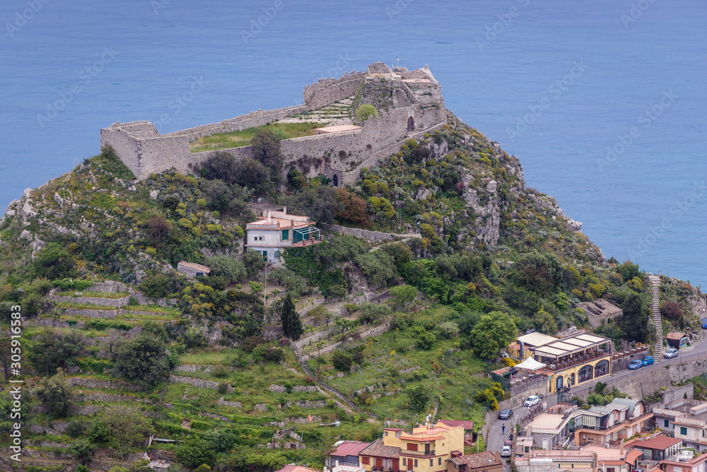 Ruins of Saracen castle on a top of the rock in Taormina city - viewm from Castelmola, small town on Sicily Island, Italy