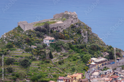 Ruins of Saracen castle on a top of the rock in Taormina city - viewm from Castelmola, small town on Sicily Island, Italy photo