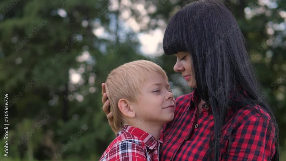 happy family mom and son concept . mom tender childhood video lifestyle . slow motion video . mom a brunette girl gently hugs takes care of the boy son blonde outdoors happy family mom and son concept . mom tender childhood video lifestyle . slow motion video . mom a brunette girl gently hugs takes care of the boy son blonde outdoors