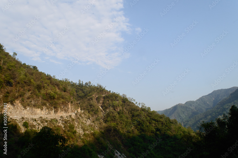 The view of mountain, blue sky, greenery, the beauty of nature of the famous neer waterfall, rishikesh, Uttarakhand, India.