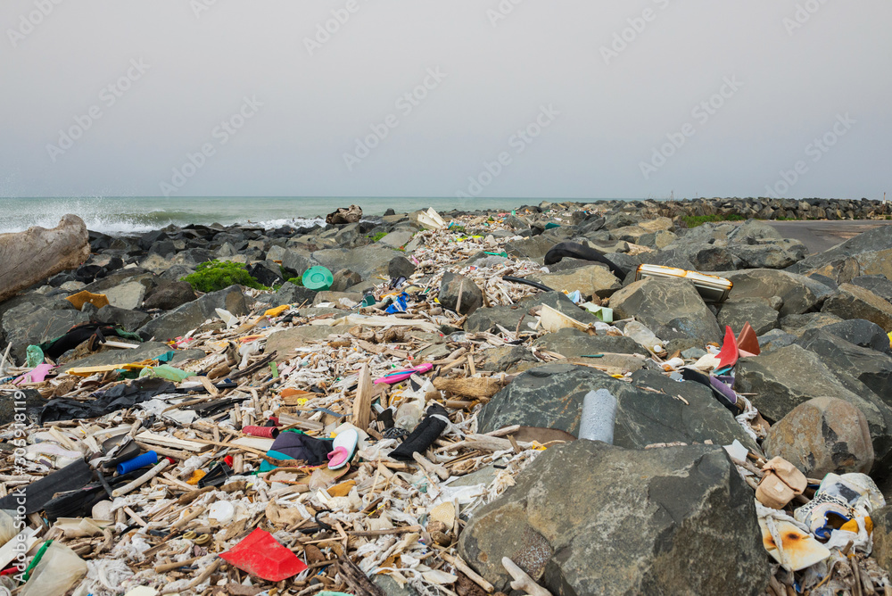 Spilled garbage on the beach near the big city. Empty used dirty plastic bottles and other garbage. Environmental pollution. Ecological problem. Spilled garbage on the beach near the big city. Empty used dirty plastic bottles and other garbage. Environmental pollution. Ecological problem.