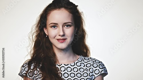 Portrait of smiling girl looking at camera over white background