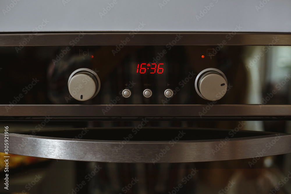 Obraz premium Electric oven with clock isolated in the kitchen.