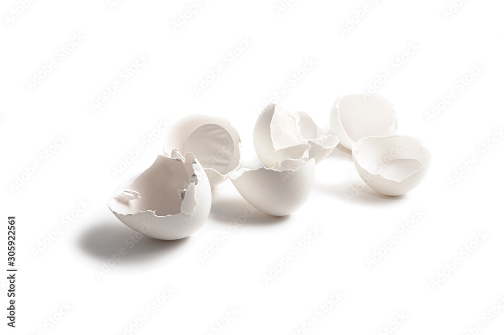 Broken egg shell isolated on white background. The texture of a beaten white egg shell. White chicken eggs on the surface. Broken egg shell isolated on white background. The texture of a beaten white egg shell. White chicken eggs on the surface.