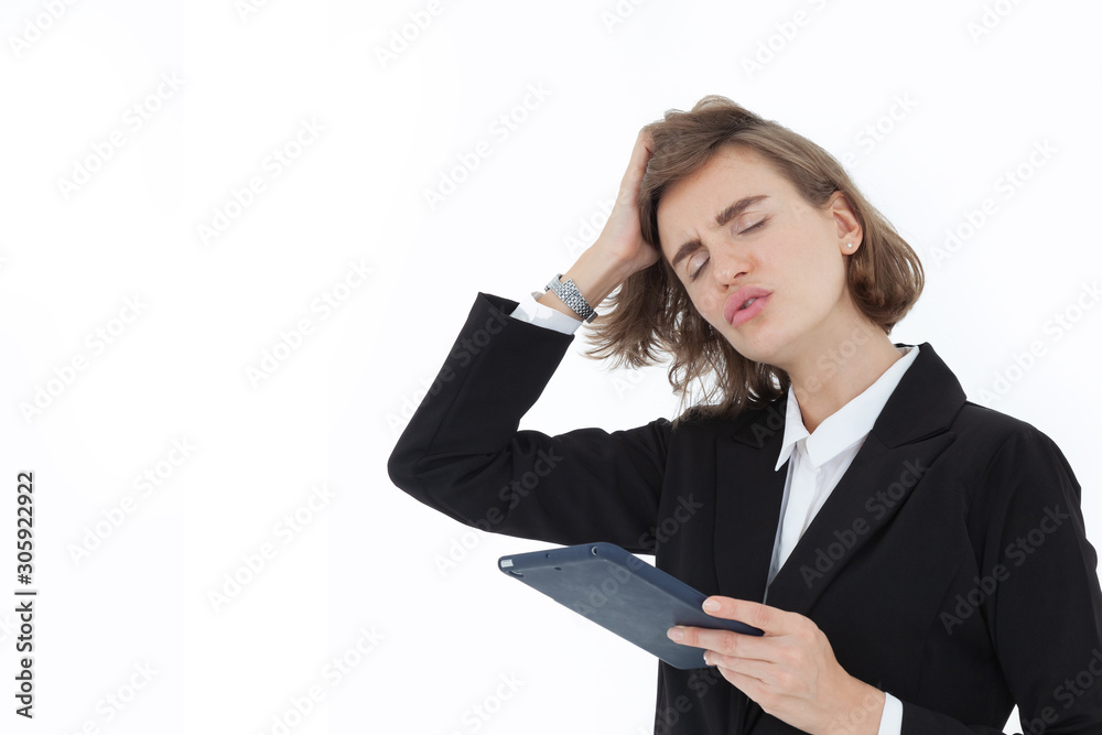 A beautiful business woman in a suit is stressed and annoyed, and holding a tablet in the other hand, on a white background in the concept of business success and inciting unity. A beautiful business woman in a suit is stressed and annoyed, and holding a tablet in the other hand, on a white background in the concept of business success and inciting unity.