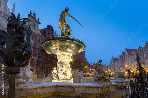 Beautiful architecture of the old town in Gdansk with Neptune fountain at dawn, Poland
