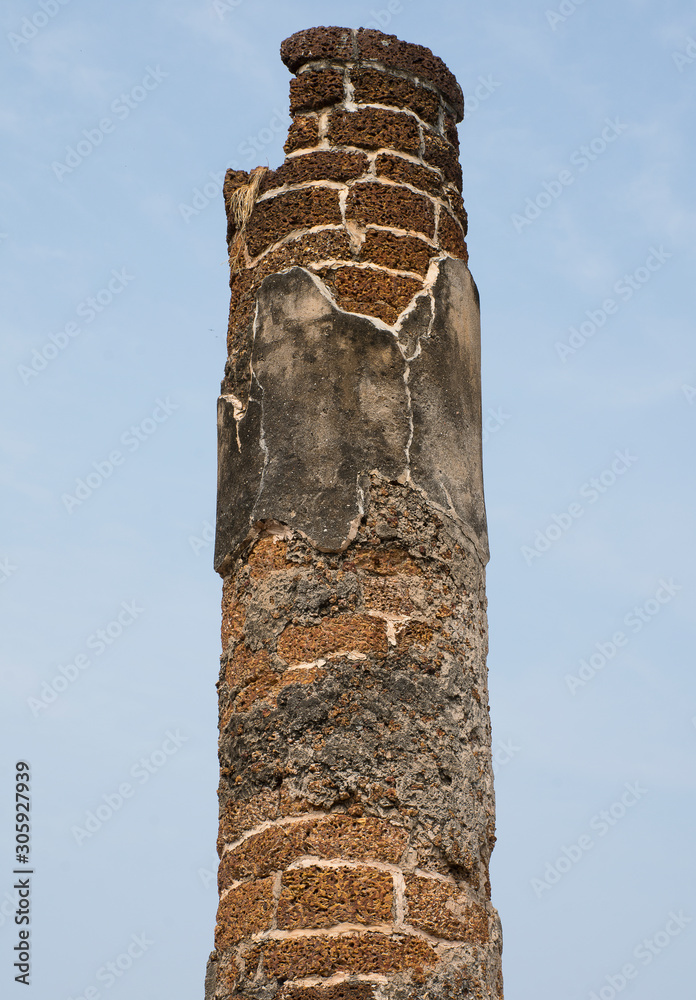 The pillars constructed of bricks and cement look old and broken.