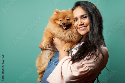 Happy woman with pug on blank blue background © Sergey
