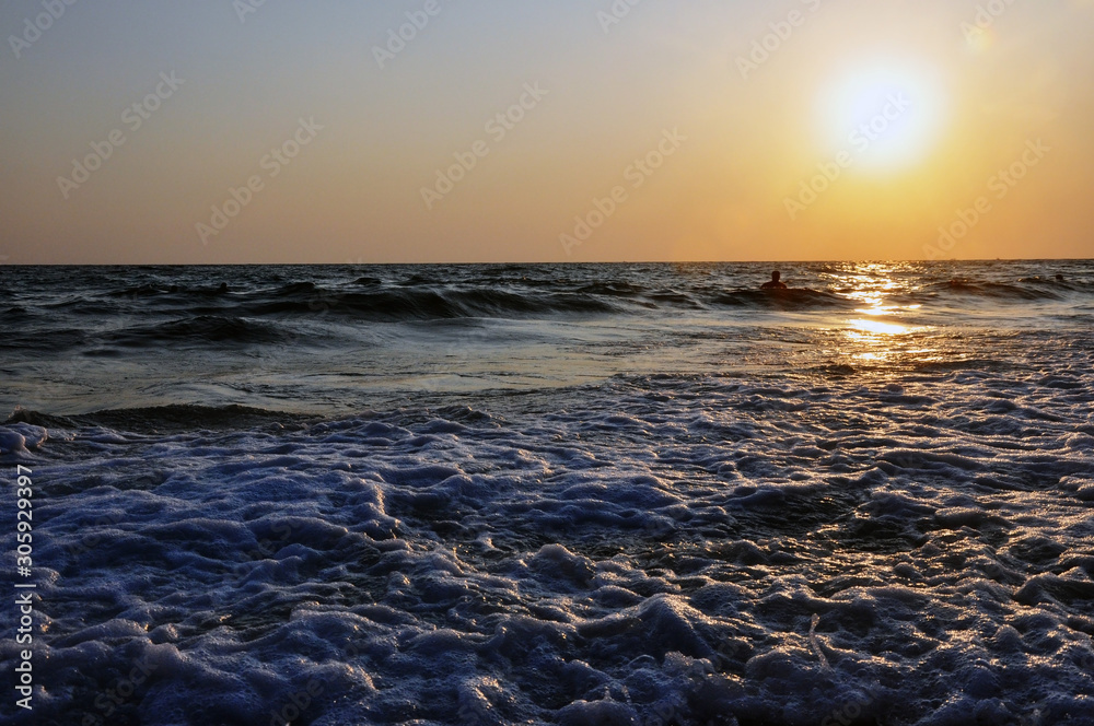 Obraz premium Tropical sunset background. Beautiful colorful ocean wave breaking closing near sand beach.