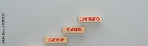 panoramic shot of wooden blocks with leadership, teamwork, contribution words on grey background, business concept © LIGHTFIELD STUDIOS