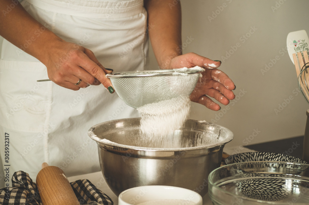 Woman adds some flour to dough on wooden table. Woman hands kneading fresh dough. Woman adds some flour to dough on wooden table. Woman hands kneading fresh dough.