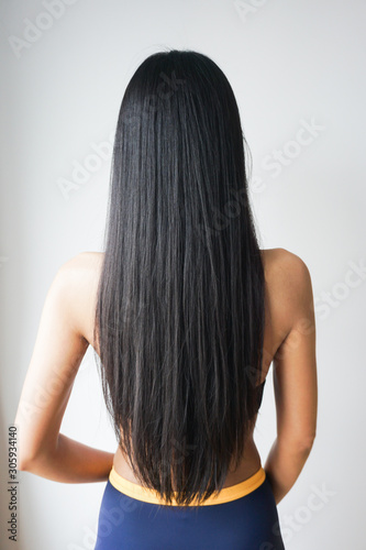 Back view of woman with beautiful long straight black hair.