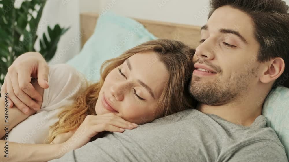 Happy couple man and woman lying together in bed and dreaming Happy couple man and woman lying together in bed and dreaming