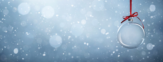 Empty christmas bauble over the winter, snowy background with copy space