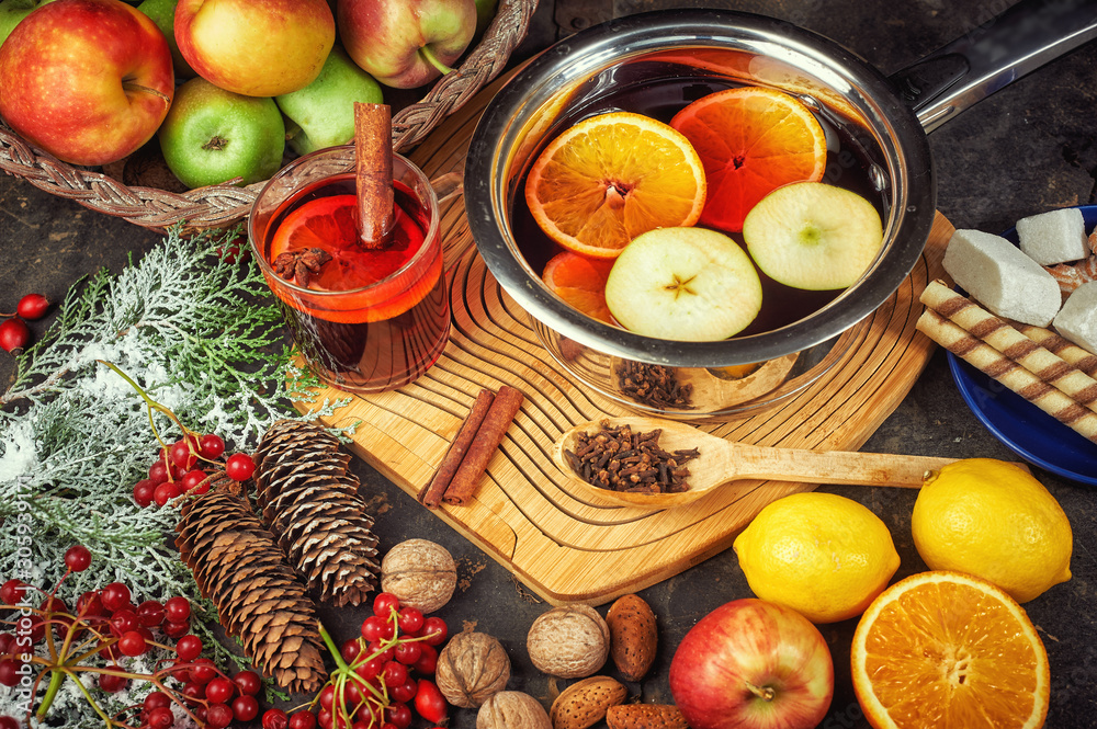 Hot drink mulled wine with citrus, apples and spices in a saucepan Hot drink mulled wine with citrus, apples and spices in a saucepan