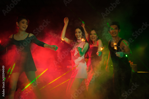 Happy new year 2023, Holiday celebrations concept, Traveller people dancing together with enjoying at colorful night party club.