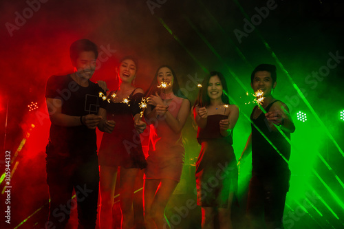 Holiday celebrations concept, Traveller people dancing together with enjoying at colourful night party club.
