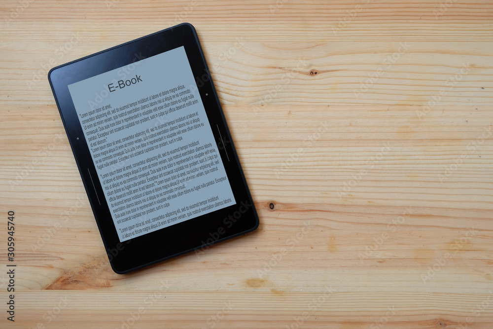 E-book reader on wooden table background, Top view. E-book reader on wooden table background, Top view.