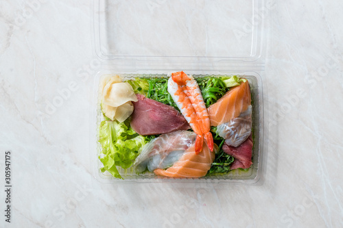 Take Away Sashimi Salad with Wakame, Seaweed, Salmon, Sea Bass, Shrimp, Kani, Mackerel Fish, Tuna in Plastic Box Package / Container. photo